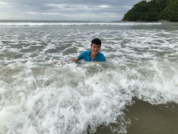 Man in sea against sky