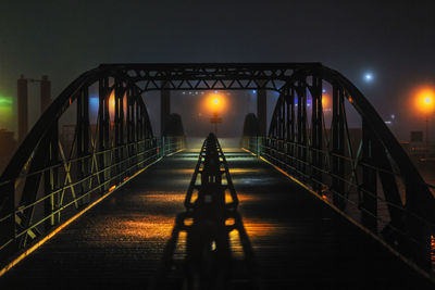 Man walking on footbridge at night