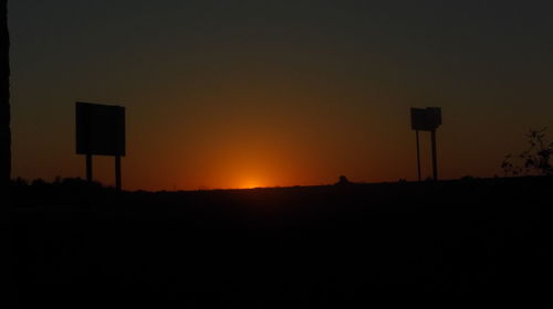 Silhouette of communications tower against sky at night