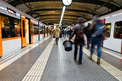 People walking on railroad station platform