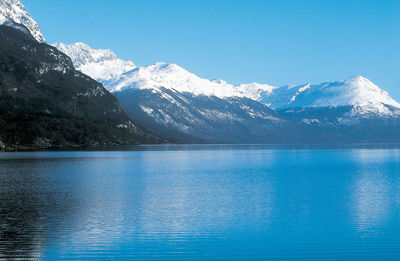 Scenic view of lake and snowcapped mountains against sky