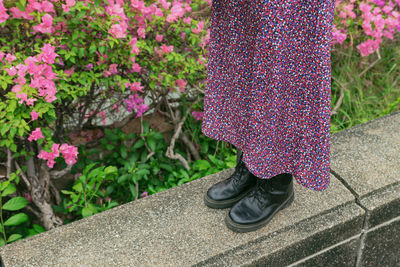 Low section of woman standing on footpath
