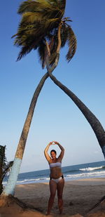 Full length of young woman standing on beach