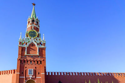 Low angle view of clock tower against blue sky