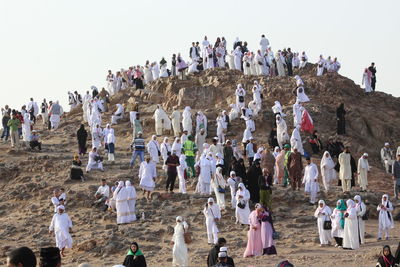 People on rock formation against sky