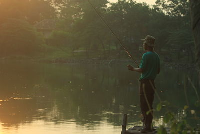 Rear view of man standing in lake