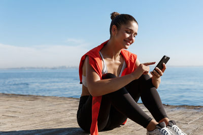 Man using mobile phone while sitting on beach