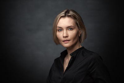 Portrait of beautiful young woman over black background