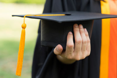 Close-up of person holding cigarette against blurred background