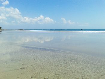 Scenic view of beach against cloudy sky