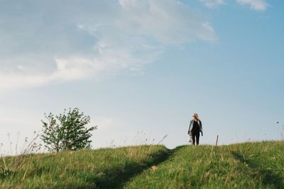 Woman standing on field against sky