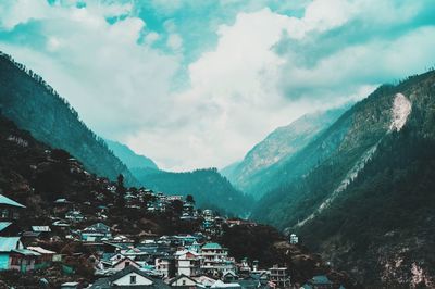 Aerial view of houses and mountains against sky