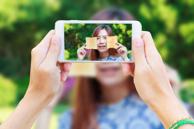 Portrait of woman photographing with mobile phone