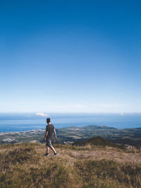 Man on shore against sky