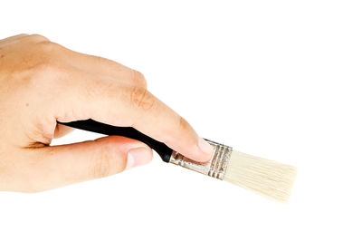 Close-up of hand holding paper against white background