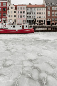 Snow covered buildings in city during winter