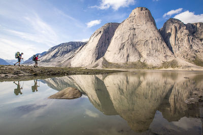 Scenic view of lake by mountains against sky