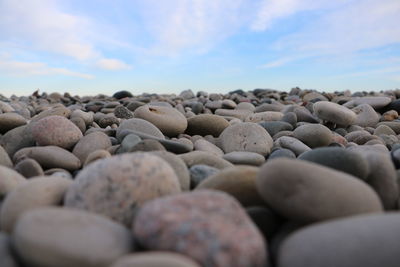 Surface level of pebble beach against sky