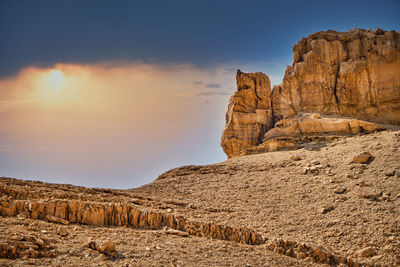 Rock formations on landscape against sky during sunset