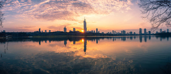 Reflection of buildings in lake during sunset