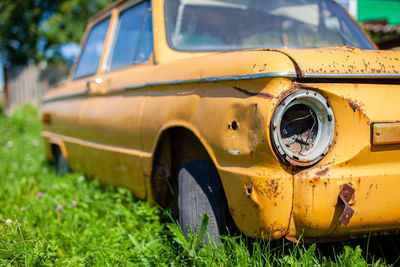 Old yellow wrecked car in vintage style. abandoned rusty yellow car. 