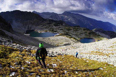 Rear view of people on snowcapped mountains against sky