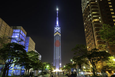 Low angle view of illuminated buildings against sky at night