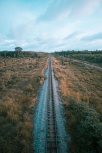 View of railroad tracks on field against sky