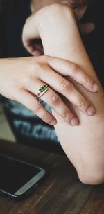 Close-up of woman wearing ring on table