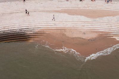 High angle view of people walking on steps by sea