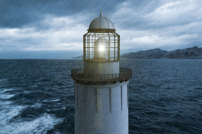 Lighthouse in the rain with the sea in the background.