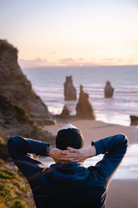 Rear view of man sitting on beach