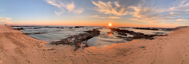 Panoramic view of beach against sky during sunset