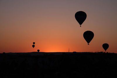 Silhouette hot air balloon against clear sky during sunset