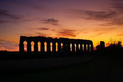 Bridge over river against sky during sunset