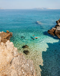 Man floating on water on beautiful beach with turquoise water on pag island in croatia.