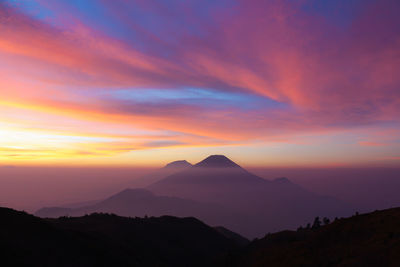 Scenic view of silhouette mountains against sky during sunrise