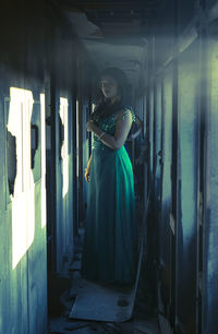 Portrait of young woman standing in train aisle