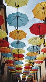 Low angle view of umbrellas hanging against sky