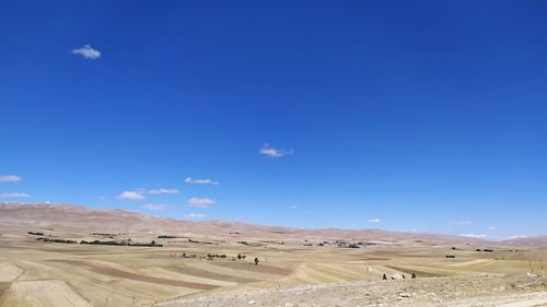 Scenic view of desert against blue sky