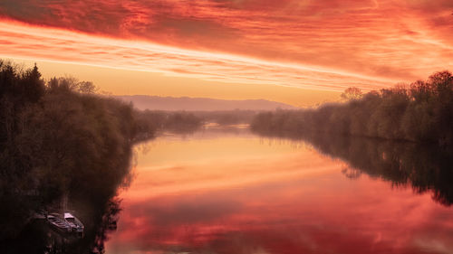 Scenic view of lake against orange sky