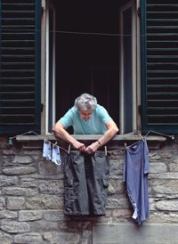 Portrait of mature man standing against window