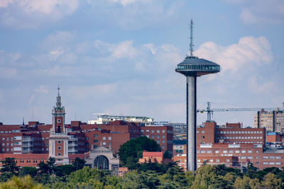 Buildings in city against cloudy sky