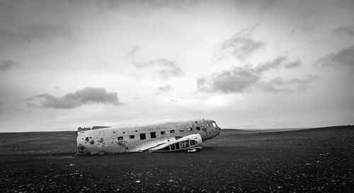 Abandoned airplane on runway against sky