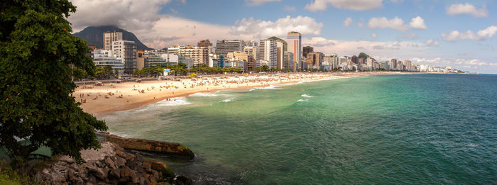 Scenic view of sea by buildings against sky