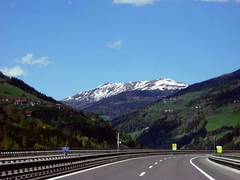 Road leading towards mountains against sky