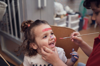 Children playing in an inner courtyard and painting with water paints