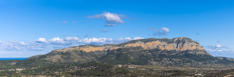 Scenic view of mountain range against blue sky