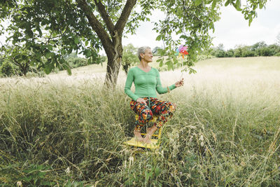 Portrait of young woman standing on field