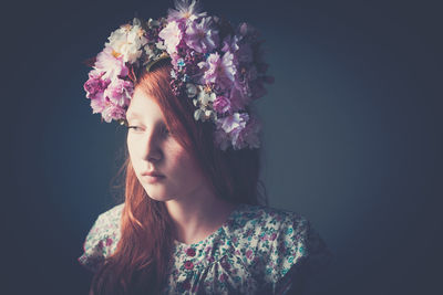 Portrait of beautiful girl and flowers against black background